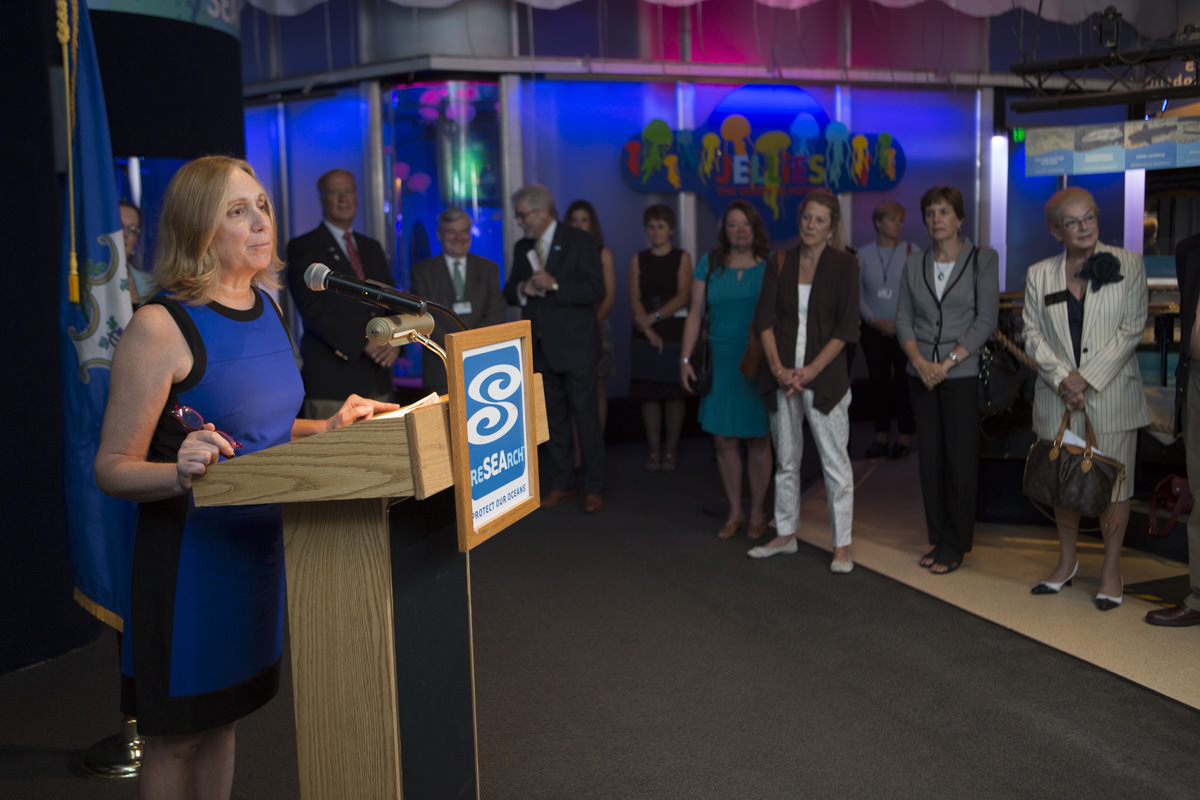 Diane Weaver Dunne takes the podium at the launch of CRISAccess at Mystic Aquarium.