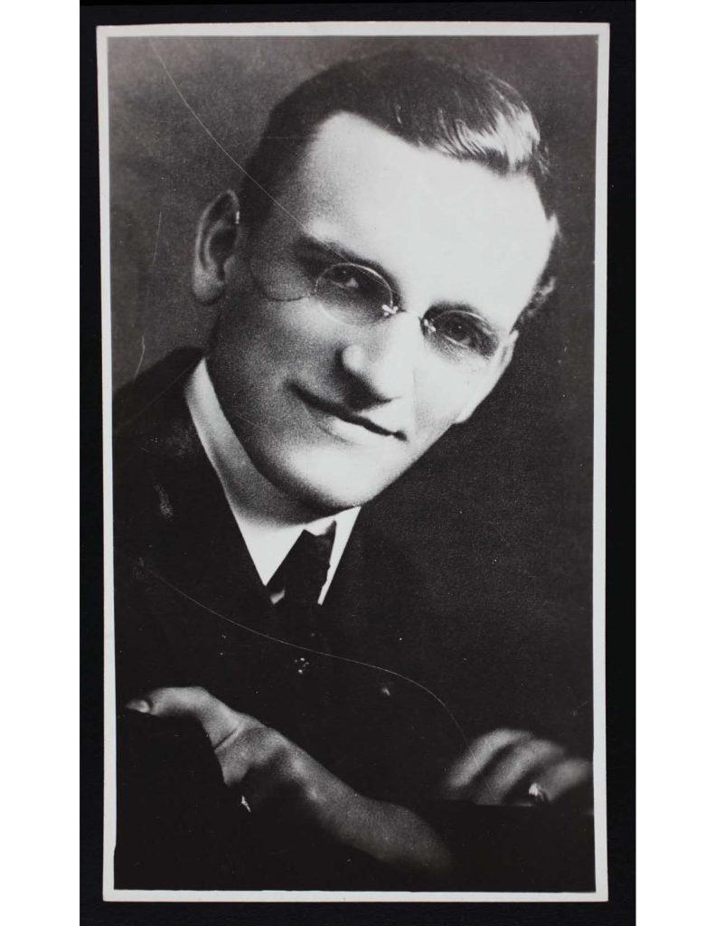 a headshot photo of lawrence thomas hager wearing a suit, tie, and glassed